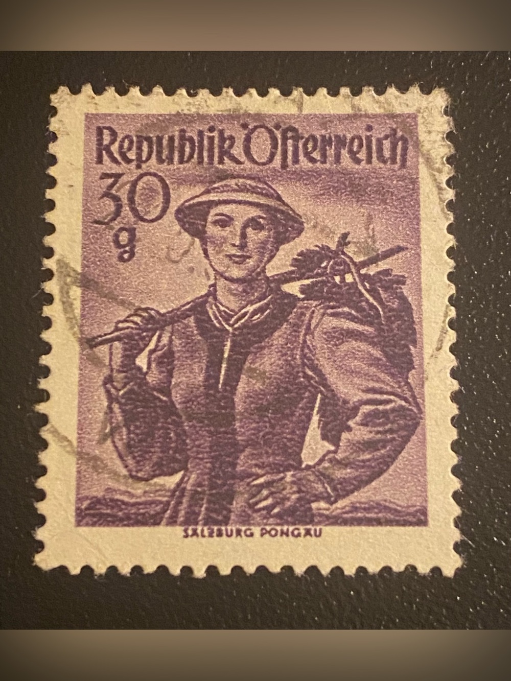 1950 Austrian postage stamp features a dark violet design depicting a woman